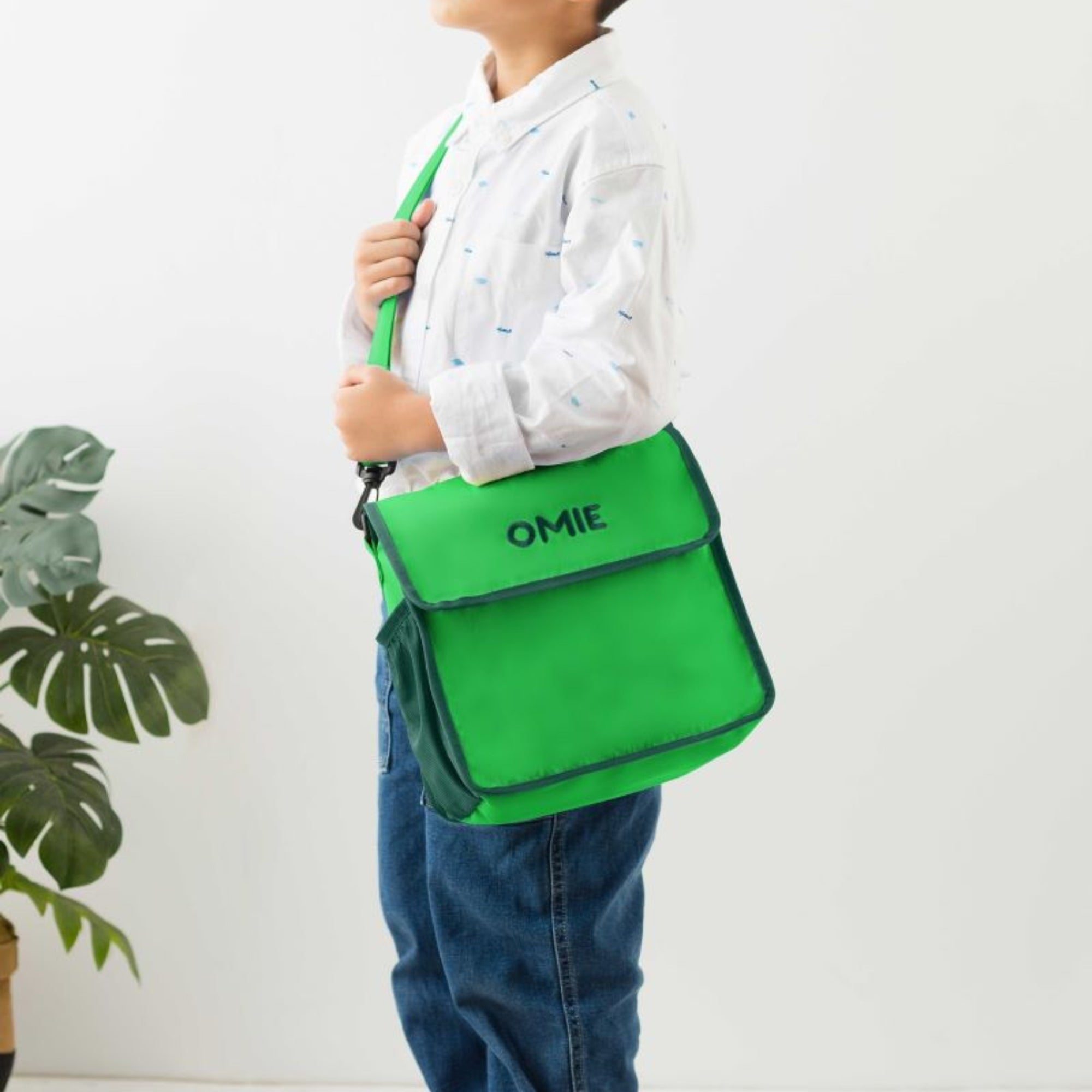 Zielona torba lunchowa dla dzieci OmieTote – wodoodporna, składana, z kieszeniami i paskiem na ramię.