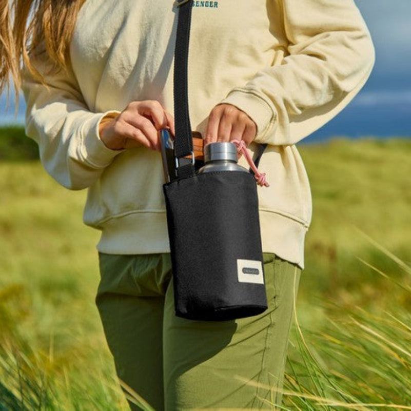 Czarna torba Black+Blum na butelkę – praktyczna, stylowa, z kieszonką i termoizolacją, idealna na spacery i podróże