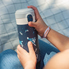 Niebieski kubek termiczny dla dzieci Monbento Pop Wolf – kompaktowy, poręczny i bezpieczny. Z izolacją próżniową, szczelny i wygodny do szkoły i na wycieczki, wzór: wilki