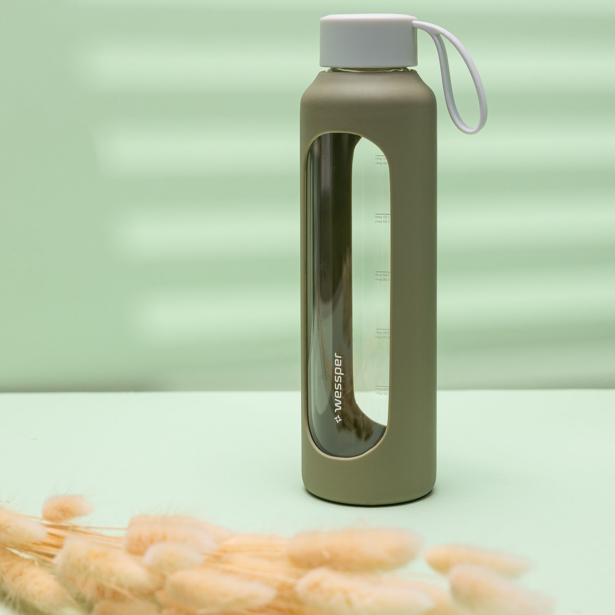 Wessper Borosilicate Olive – zielona, szklana butelka motywacyjna 500 ml. Szkło borokrzemowe, silikonowe etui, szczelna zakrętka, miarka godzinowa, bez BPA, do zimnych i gorących napojów.